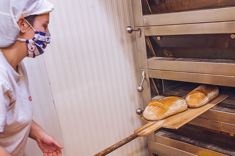 Pekařka před pecí s chlebem